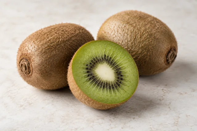 Kiwi verde, întreg și tăiat în jumătate